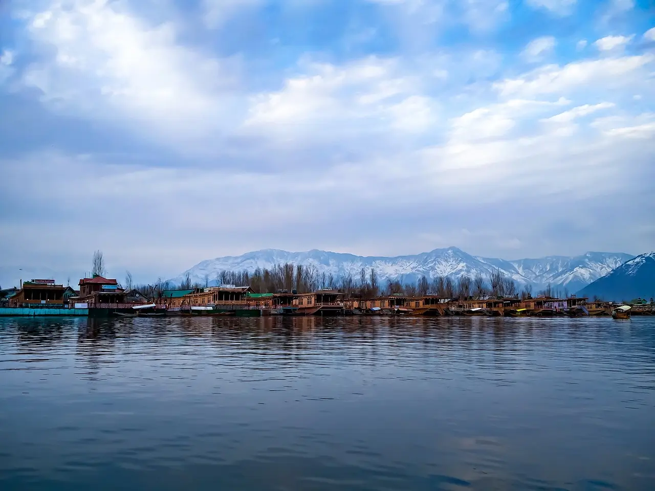 Scenic view of Dal Lake in Srinagar, Kashmir, with traditional Shikara boats floating on the calm waters